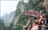 ?? WANG ZHONGJU / CHINA NEWS SERVICE ?? Tourists enjoy a meal on a cliffside path more than 2,000 meters above the ground on Laojun Mountain in Luoyang, Henan province, on Sunday. The event was part of a two-month tourism festival, which runs through Aug 31.