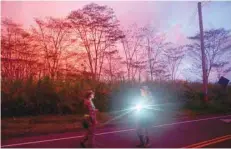  ?? Reuters — ?? A lava flow illuminate­s the evening sky above soldiers of the Hawaii National Guard near Pahoa during ongoing eruptions of the Kilauea volcano in Hawaii.