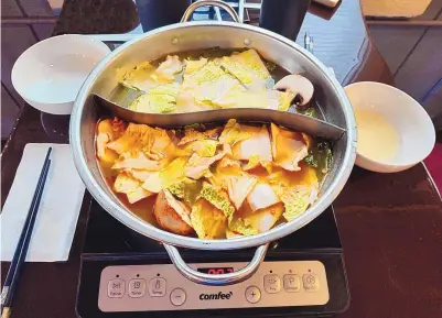  ?? RICHARD S. DARGAN/FOR THE JOURNAL ?? Vegetables fill a pot divided into Thai Curry (bottom) and Chinese Herb broths.