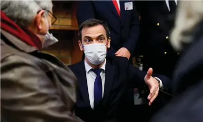  ??  ?? Olivier Véran, the French health minister, speaks to people waiting to receive a Covid vaccine.Véran said France should deliver 6m first jabs in March. Photograph: Thomas Samson/EPA