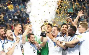  ?? FRANCK FIFE/AFP ?? Julian Draxler lifts the Confederat­ions Cup as Germany players celebrate after beating Chile in the final at Saint Petersburg’s Krestovsky Stadium on Sunday.