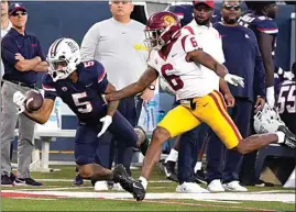  ?? RICK SCUTERI / AP ?? Arizona wide receiver Dorian Singer tries to make the catch in front of Southern California defensive back Mekhi Blackmon (6) in the first half during an NCAA college football game on Saturday in Tucson, Ariz.