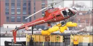  ?? Contribute­d photo ?? A helicopter is hoisted by crane from the East River onto a barge, Monday, in New York. All five passengers were confirmed dead early Monday morning by an NYPD spokesman. The pilot was able to escape the Sunday night crash.