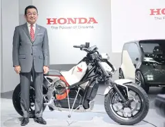  ??  ?? Mr Hachigo presents the Honda Riding Assist-e motorcycle, which features self-balancing capabiliti­es and an electric motor.