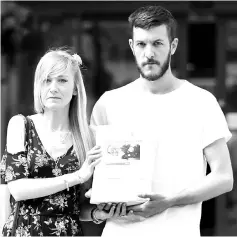  ?? — AFP photo ?? Connie and Chris pose with a petition of signatures supporting their case, prior to delivering it to the Great Ormond Street Hospital for Children in central London.