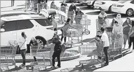  ?? JOHN LOCHER/AP ?? People wait in line to buy supplies at a Costco on Saturday in Las Vegas.