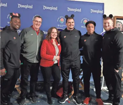  ?? RICK WOOD / JOURNAL SENTINEL ?? Disneyland vice president Kris Theiler (a Wisconsin native ) poses with head coach Paul Chryst (second from left) and UW players (from left) Chris Orr, Zack Baun, Jonathan Taylor and Tyler Biadasz.