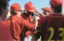  ?? KARL MERTON FERRON/BALTIMORE SUN ?? Calvert Hall’s Clover Garrick is mobbed by teammates after scoring on a hit by Michael Copenspire during Wednesday’s MIAA A Conference game.