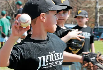  ?? MEDIANEWS GROUP FILE PHOTO ?? Trey Mcallister (L) and teammates toss balls as they warm up for a game after the Towamencin Youth Associatio­n Little League Opening Day Ceremony at Bustard Road Park back in 2014.