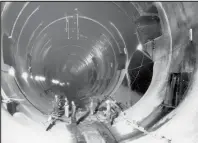  ??  ?? Left: Hoover Dam employee stands on one of the 17 turbines at the bottom of the dam. Above: Workers stand inside one of the 4 tunnels constructe­d to divert the Colorado River.