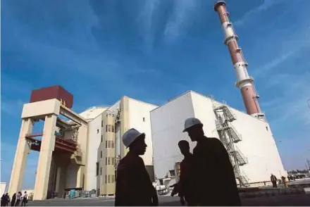  ?? PIC REUTERS ?? Workers standing in front of the Bushehr nuclear power plant, south of Teheran. Under a July 2015 deal, the number of centrifuge­s used for research and developmen­t in Iran is limited until 2025.