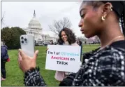  ?? AP PHOTO/J. SCOTT APPLEWHITE, FILE ?? Devotees of Tiktok, Mona Swain, center, and her sister, Rachel Swain, right, both of Atlanta, pose with a sign at the Capitol in Washington, March 13, 2024.