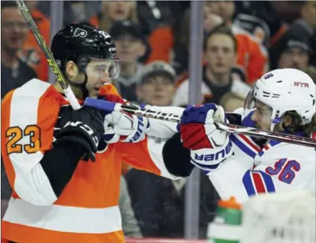  ?? TOM MIHALEK — THE ASSOCIATED PRESS ?? The Flyers’ Brandon Manning, left, retaliates against Manning’s face during the third period Saturday. the Rangers’ Mats Zuccarello after Zuccarello shoved his stick in
