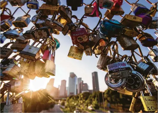  ?? Marie D. De Jesús / Staff photograph­er ?? View of the skyline of Houston surrounded by love locks on the pedestrian bridge over Allen Parkway
