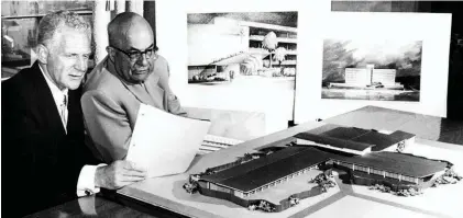  ??  ?? Dr. Sidney Garfield, left, and Henry J. Kaiser review some models for hospital constructi­on in the early 1950s. Garfield started his prepaid care model with one 12-bed hospital in the 1930s. Today, the Kaiser system has 39 hospitals.