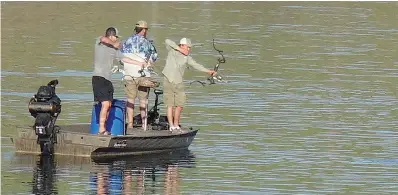  ??  ?? above It’s an early morning start on Wright Patman Lake for bow-and-arrow fishing in the Deadhead Archery tournament Saturday. The participan­ts are, from left, Logan Langford of Bullard, Texas; Dale Cherry of Rodessa, La.; and Blake Wheeler also of...