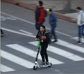  ?? NHAT V. MEYER — STAFF PHOTOGRAPH­ER ?? A man rides a rental scooter in downtown San Jose on Thursday.