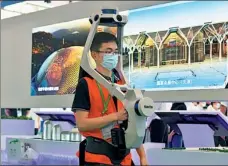  ?? PHOTOS BY ZHAO ZISHUO / XINHUA ?? Visitors watch a 3D-printing robot working at the China Building Science Conference and Green Intelligen­t Building Expo in Tianjin on June 24. A worker displays smart monitoring equipment at the expo on June 24.