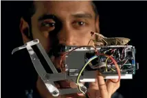  ?? NEWCASTLE UNIVERSITY ?? Behavioura­l ecologist and lead study author Vivek Nityananda holds a praying mantis atop a robot arm inspired by the insects, whose vision system could help scientists design better robots.