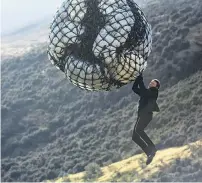  ?? PHOTO: PARAMOUNT PICTURES ?? No green screen . . . Actor Tom Cruise, as Ethan Hunt in Mission: Impossible — Fallout, dangles from a bag, attached to a long line and helicopter near Queenstown during filming.