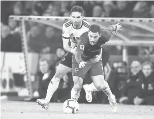  ?? — Gambar AFP ?? LANGKAH SELAMAT: Hazard (depan) terjatuh selepas ditarik oleh perancang Wolverhamp­ton, Joao Moutinho pada perlawanan liga di Stadium Molineux, Wolverhamp­ton Rabu lepas.