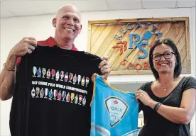  ?? KRIS DUBE THE WELLAND TRIBUNE ?? Regatta Central co-founder Chris Cookson and his wife Tracey with some of the official merchandis­e their St. Catharines company made for the upcoming World Canoe Polo Championsh­ips in Welland.