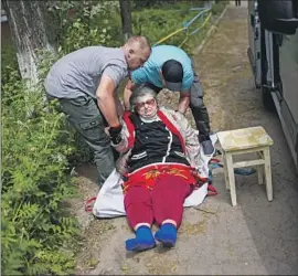  ?? Francisco Seco Associated Press ?? VOLUNTEERS carry a woman from her home during an evacuation in Kramatorsk, eastern Ukraine, near the front line of the ongoing war with Russia.