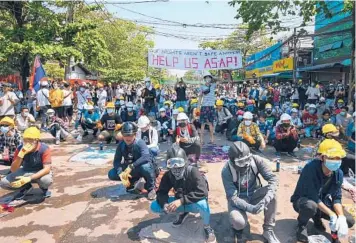  ?? GETTY/AFP ?? Myanmar protests: Protesters wear makeshift protective equipment as they prepare to face off against security forces during a demonstrat­ion against the military coup Friday in Yangon. Meanwhile, the U.N. special envoy for the country called for urgent Security Council action, saying about 50 peaceful protesters were killed and scores were injured this week.