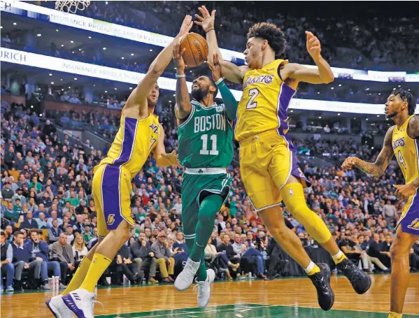  ?? ASSOCIATED PRESS ?? Boston Celtics guard Kyrie Irving (11) goes between Los Angeles Lakers' Lonzo Ball (2) and Brook Lopez during the fourth quarter of Boston's 107-96 win in an NBA basketball game in Boston.