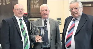  ??  ?? Paul Sutcliffe is presented with the trophy by sponsor Angus Abraham and captain Mark Warren