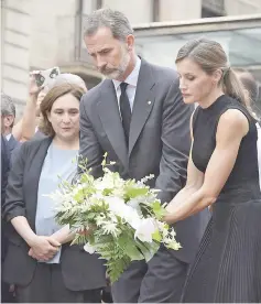  ??  ?? King Felipe VI and Queen Letizia lay a wreath of flowers for the victims of the Barcelona attack on Las Ramblas boulevard next to Barcelona’s mayor Ada Colau. — AFP photo
