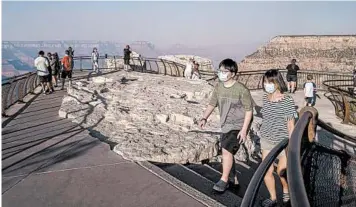  ?? ADRIANA ZEHBRAUSKA­S/THE NEW YORK TIMES ?? Visitors take in the beauty of Grand Canyon National Park. National parks are grappling with how to stay open safely.