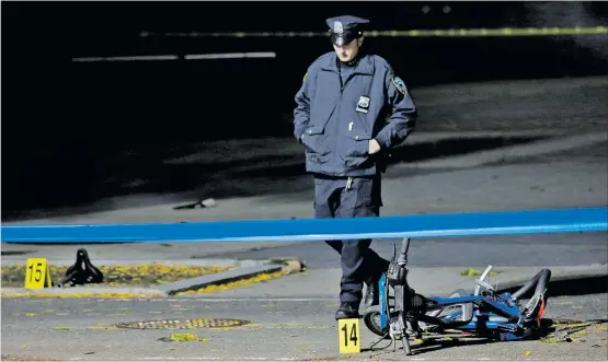  ?? [ Reuters ] ?? Nach dem Anschlag: Ein Polizist untersucht den Tatort in Manhattan, wo ein Mann mit einem Lieferwage­n Radfahrer und Fußgänger niedermäht­e.