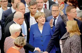  ?? AP ?? German Chancellor Angela Merkel, center, gestures as a lawmaker raises a “No” polling card at the Reichstag building on same-sex marriage in Berlin, Germany. —