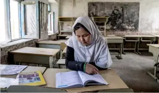  ?? ?? Une fille lit un livre dans sa classe le premier jour de la nouvelle année scolaire à Kaboul.