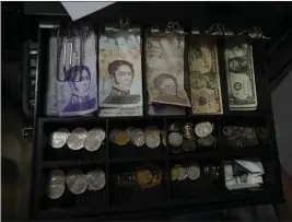  ?? ARIANA CUBILLOS — THE ASSOCIATED PRESS ?? A cash register drawer holds Bolivars and U.S. currencies at a shop in Caracas, Venezuela, on Friday.