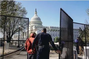  ?? AMR ALFIKY/THE NEW YORK TIMES ?? A Capitol Police officer opens a gate outside the Capitol building Saturday in Washington, near where a car rammed into a security barrier Friday, killing an 18-year veteran of the force. The driver was shot and killed.