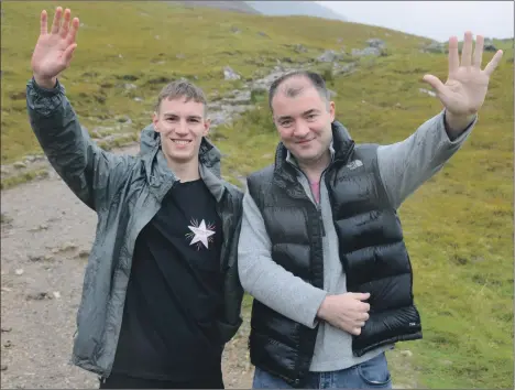  ?? Photograph­s: Iain Ferguson, The Write Image. ?? A high fIve from Cameron Main, left, after his five successful conquests of Ben Nevis in less than a day, which raised £5,500 in memory of his sister. He is pictured with record holder Charlie Anderson of Fort William.