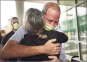  ?? ?? Florida resident Robby Walker hugs medical staff, left; at right, the staff applauds as he is released.