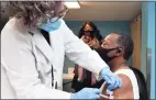  ?? Arnold Gold / Hearst Connecticu­t Media ?? Registered nurse Rosellen Moore, left, vaccinates Bishop Phillip Boone of the Cathedral of Higher Praise-Church of God Prophecy at a pop-up clinic in New Haven on Feb. 10.