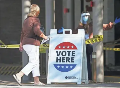  ?? ROB SCHUMACHER/THE REPUBLIC ?? A citizen approaches an early voting center Wednesday at Paradise Valley Community College in Phoenix.