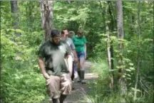  ?? CHARLES PRITCHARD - ONEIDA DAILY DISPATCH ?? Interns walk the trails at the Great Swamp Conservanc­y on July 2.