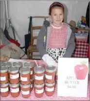  ??  ?? Molly Helm, 9, helped her grandmothe­r, Jean Helm, sell jars of apple butter as a fundraiser for the Arkansas Apple Festival.
