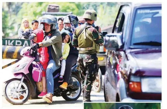  ?? Balmores) (Mark ?? A FAMILY of four aboard a motorcycle passes a checkpoint in Pantar, Lanao del Norte, some 10 kilometers from Marawi.