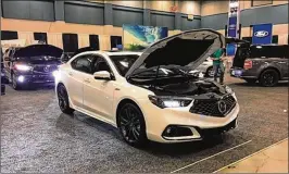  ?? THOMAS GNAU / STAFF ?? New Acuras and Fords are displayed in the Dayton Convention Center as part of the Dayton Auto Show which opens at noon today. Organizers see strong interest in the show. Generally, a healthy auto industry means a healthy interest in auto shows.