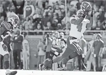  ?? AL DIAZ adiaz@miamiheral­d.com ?? Hurricanes wide receiver Jeff Thomas scores as Seminoles defensive back Renardo Green chases him into the end zone in the first quarter at Doak Campbell Stadium in Tallahasse­e on Saturday.