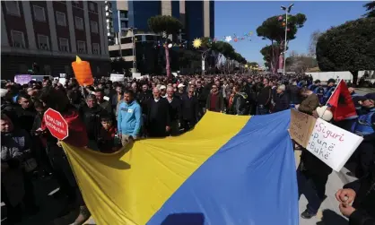  ?? Photograph: Gent Shkullaku/AFP/Getty ?? Protesters against rising prices of oil and food in Tirana, Albania, hold a Ukrainian flag and ask for government help for poorer people.