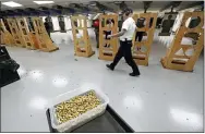  ?? TED S. WARREN, FILE - THE ASSOCIATED PRESS ?? In this 2019file photo, an officer taking part in training walks near a box of ammunition at the Washington State Criminal Justice Training Commission in Burien, Wash. The Covid-19pandemic coupled with record sales of firearms have created a shortage of ammunition in the United States that has impacting competitio­n and recreation­al shooters, hunters, people seeking personal protection and law enforcemen­t agencies.