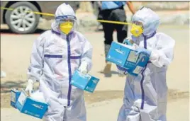  ?? PTI ?? Healthcare workers in PPE suits carry syringes towards a Covid-19 vaccinatio­n centre in Jammu on Saturday.