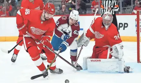  ?? PAUL SANCYA/AP ?? Detroit Red Wings defenseman Jake Walman (96) and Colorado Avalanche left wing Artturi Lehkonen (62) battle for the puck as goaltender Alex Lyon (34) looks on in the third period Feb. 22 at Little Caesars Arena in Detroit.